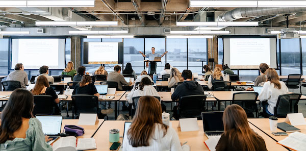 A classroom at the Watermark Institute is filled with students learning theological lessons, featuring Blake Holmes as the teacher.